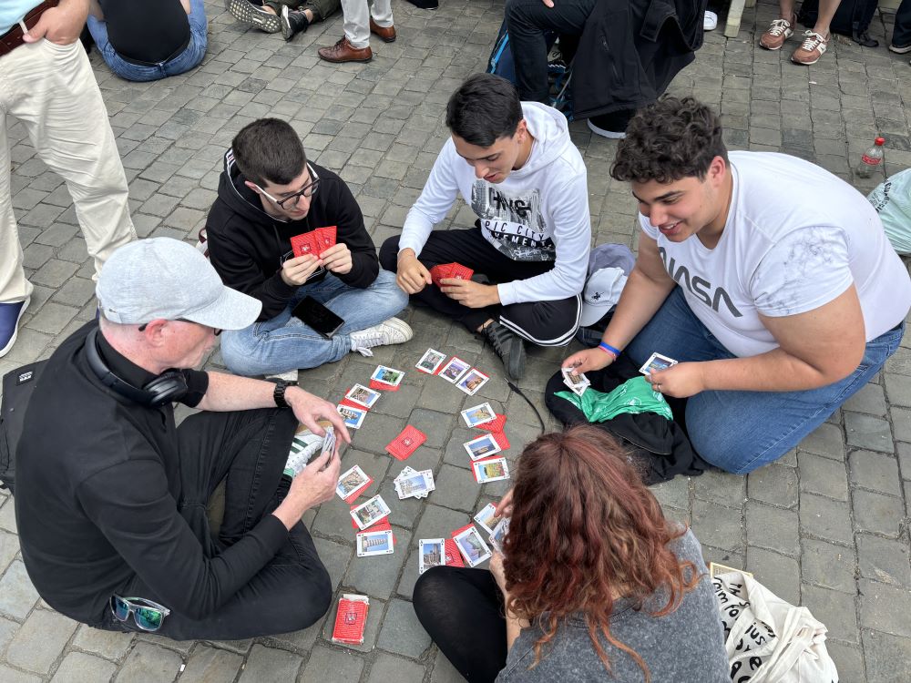 A group of Italian teens leaned against each other and napped while awaiting smoke from the Sistine Chapel May 8 until a man nearby offered to teach them a card game. Black smoke, indicating the cardinals had not yet chosen a new pope, flowed from the chimney on the Sistine Chapel at 11:51 a.m. Rome time. (NCR photo/Olivia Bardo) A group of Italian teens leaned against each other and napped while awaiting smoke from the Sistine Chapel May 8 until a man nearby offered to teach them a card game. Black smoke, indicating the cardinals had not yet chosen a new pope, flowed from the chimney on the Sistine Chapel at 11:51 a.m. Rome time. (NCR photo/Olivia Bardo)