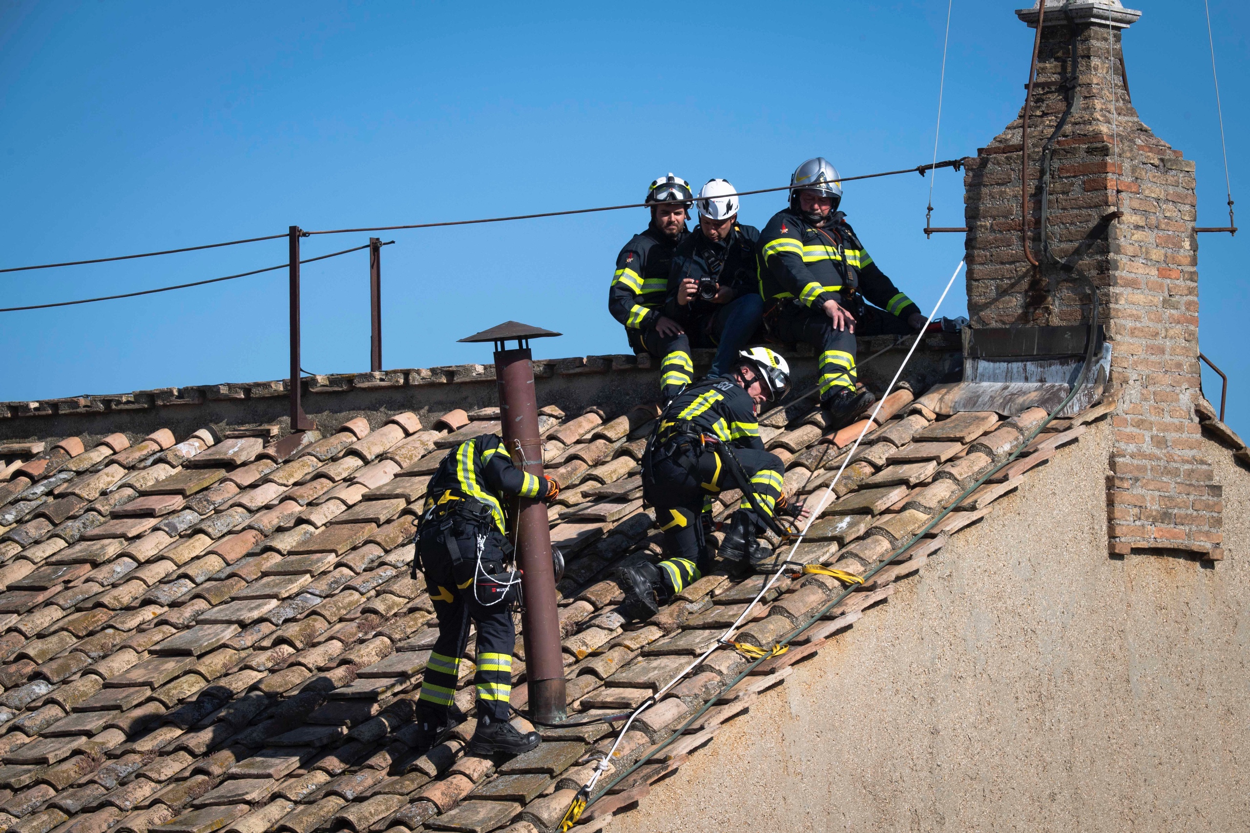 Vatican firefighters install the chimney on the roof of the Sistine Chapel at the Vatican May 2, 2025. Connected to a stove in the chapel where the ballots will be burned during the conclave to elect a new pope, the chimney will signal to the world whether a new pope has been elected. (CNS photo/Vatican Media)