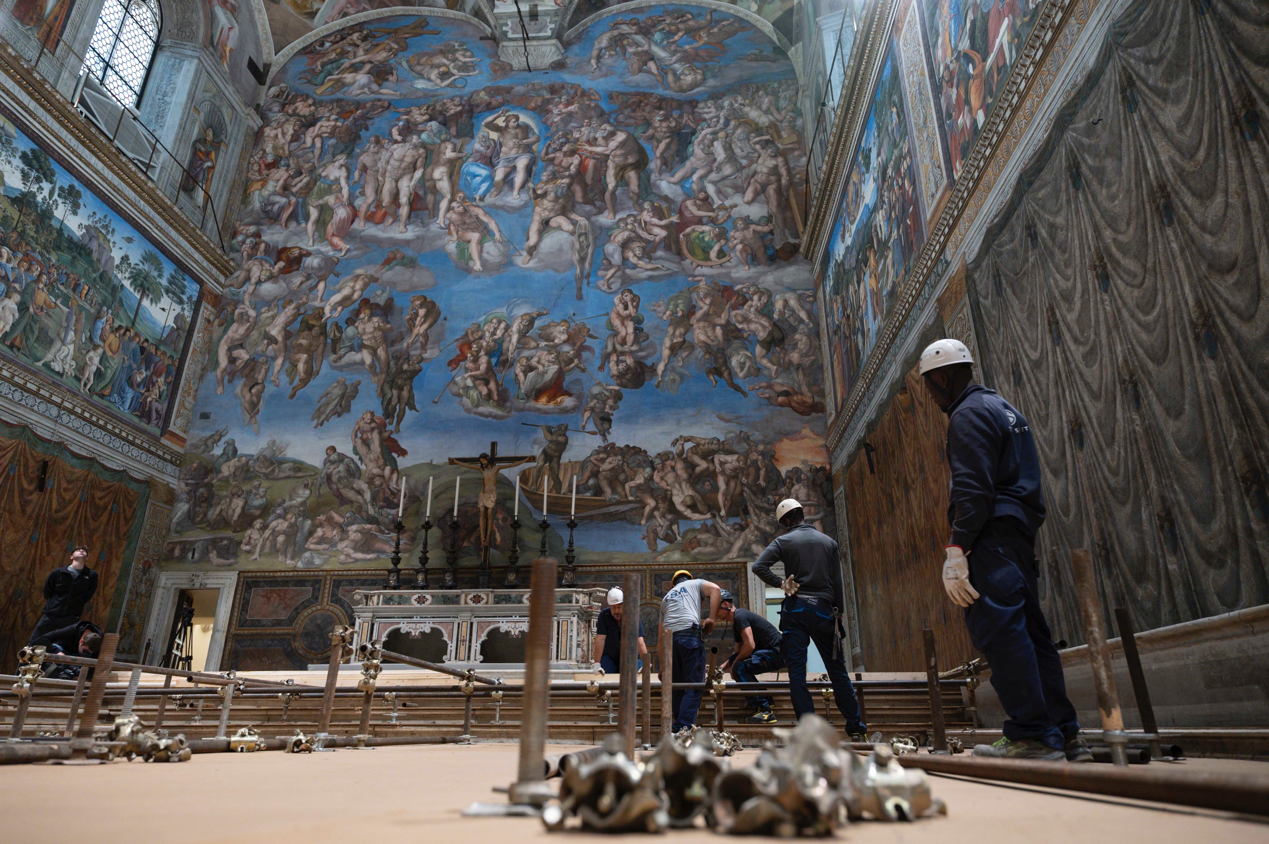 In preparation for the conclave to elect a new pope, workers build platforms over a protective covering on the marble floor of the Sistine Chapel at the Vatican May 2, 2025. The cardinals who enter the conclave May 7 will sit at tables facing the center with the tables in the back row raised slightly. (CNS photo/Vatican Media)