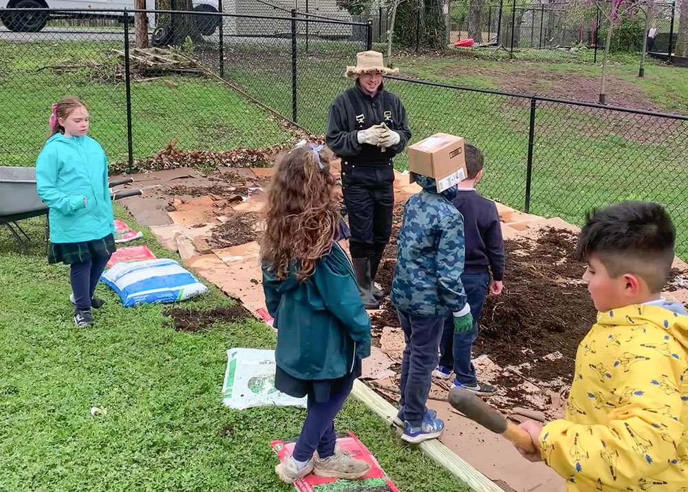 Students at St. Agatha Academy in Winchester, Kentucky, get their hands dirty in helping prepare the ground and plant seeds for a butterfly garden at their school. The project is part of the Laudato Si' plan for St. Joseph Catholic Church. (James Kinney)