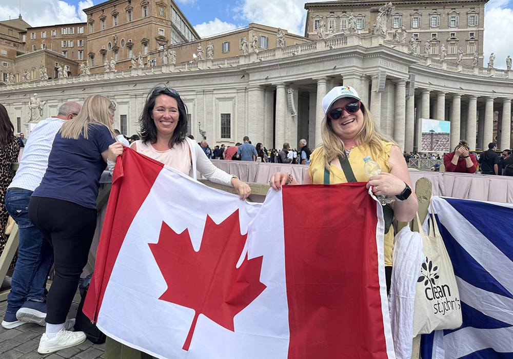 Elizabeth Whelan of Newfoundland, on right, holds a Canadian flag May 8 in St. Peter's Square. (NCR photo/Rhina Guidos)
