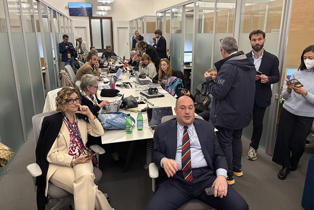 Minutes before the black smoke billowed out of the chimney on Wednesday, May 7, the media in the work space of the Holy See Press Office watched a video broadcast of Vatican Square. (NCR photo/James V. Grimaldi)
