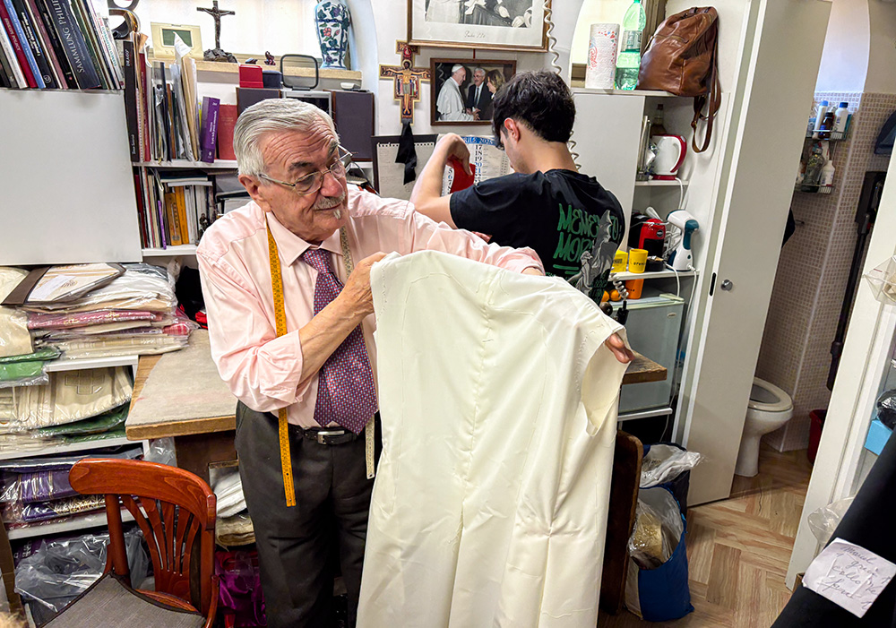 In his workshop in Rome by the Vatican, Raniero Mancinelli holds one of the three papal robes that he is preparing for the next pope to wear on the day of his election. (Camillo Barone)