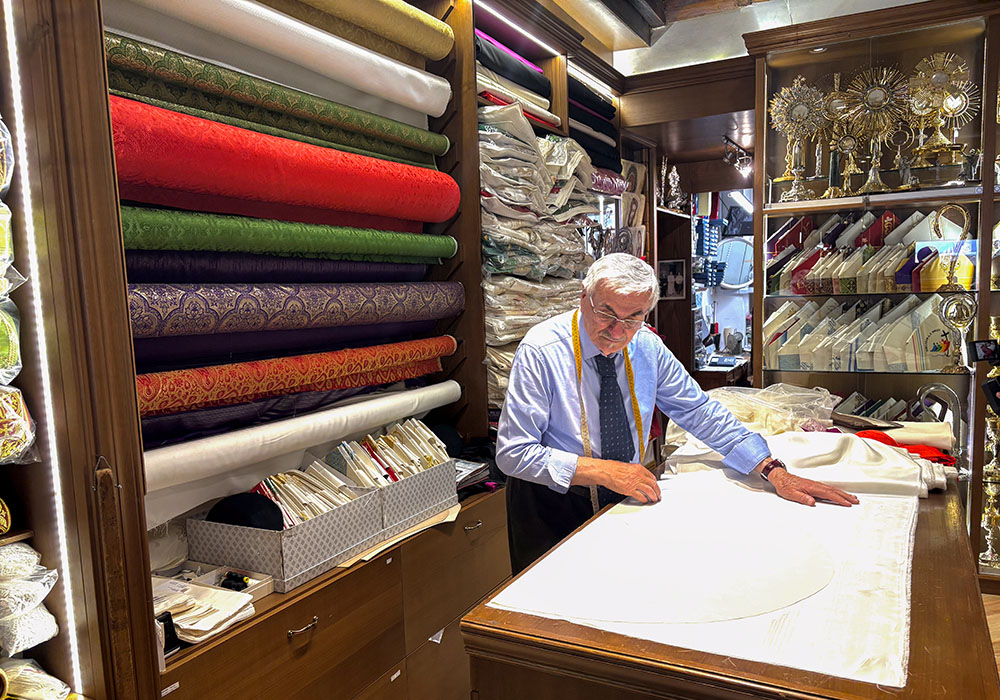 In his store in Rome by the Vatican, Raniero Mancinelli works on one of the three papal robes that he is preparing for the next pope to wear on the day of his election. (Camillo Barone)