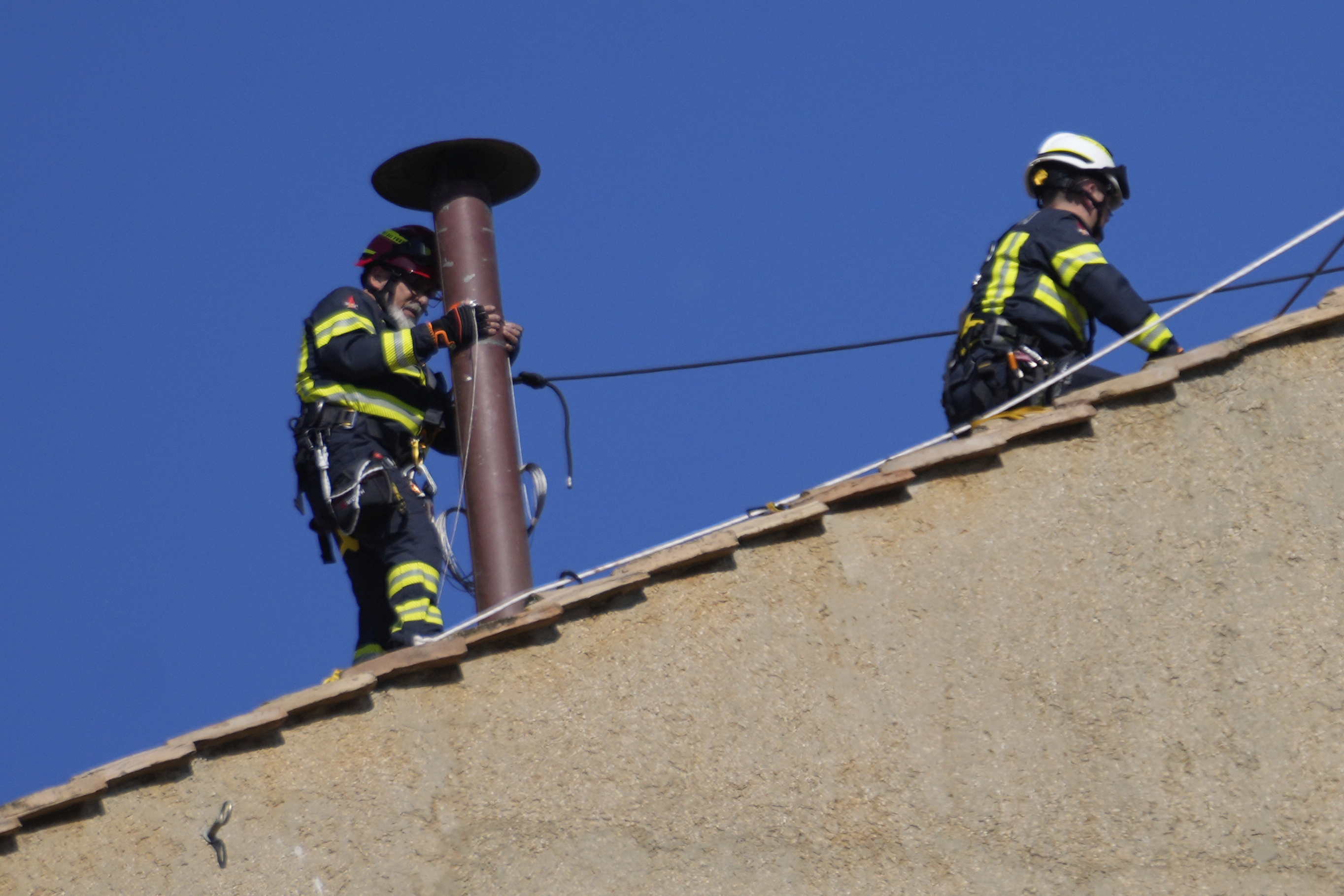 Firefighters place the chimney on the roof of the Sistine Chapel, where cardinals will gather to elect the new pope, at the Vatican, Friday, May 2, 2025. (AP Photo/Gregorio Borgia) Firefighters place the chimney on the roof of the Sistine Chapel, where cardinals will gather to elect the new pope, at the Vatican, Friday, May 2, 2025. (AP Photo/Gregorio Borgia)