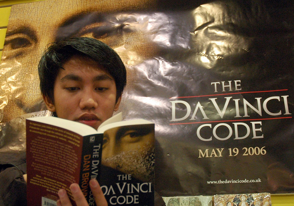 A man reads The Da Vinci Code at a bookstore in Manila, Philippines, on May 13, 2006. The film adaptation was released in 2006. Fr. Andrew Greeley wrote an NCR book review of Dan Brown's novel in 2003. (CNS/Reuters/Joseph Agcaoli)