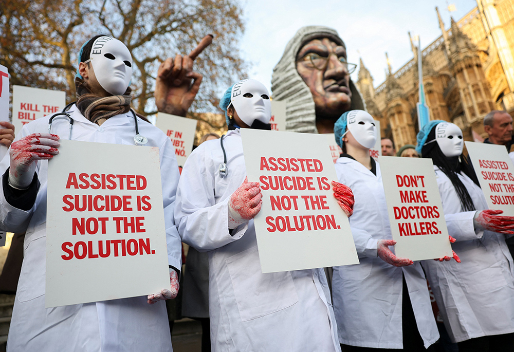 Protesters hold a placard outside Parliament in London as British lawmakers debate an assisted suicide bill on Nov. 29, 2024. (OSV News/Reuters/Mina Kim)