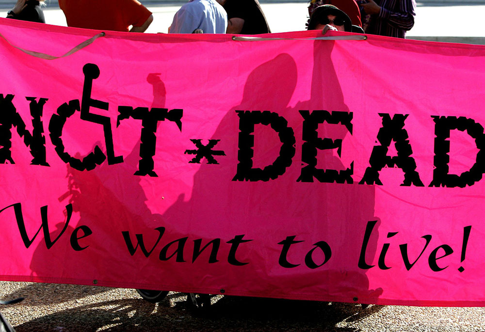 A file photo shows disabled protesters against physician-assisted suicide silhouetted as they hold up a banner outside the U.S. Supreme Court. The New York Assembly passed a bill April 29, 2025, that would legalize medically assisted suicide in the state. State senators passed the Medical Aid in Dying Act 35-27 on June 9. (OSV News/Reuters/Jason Reed)