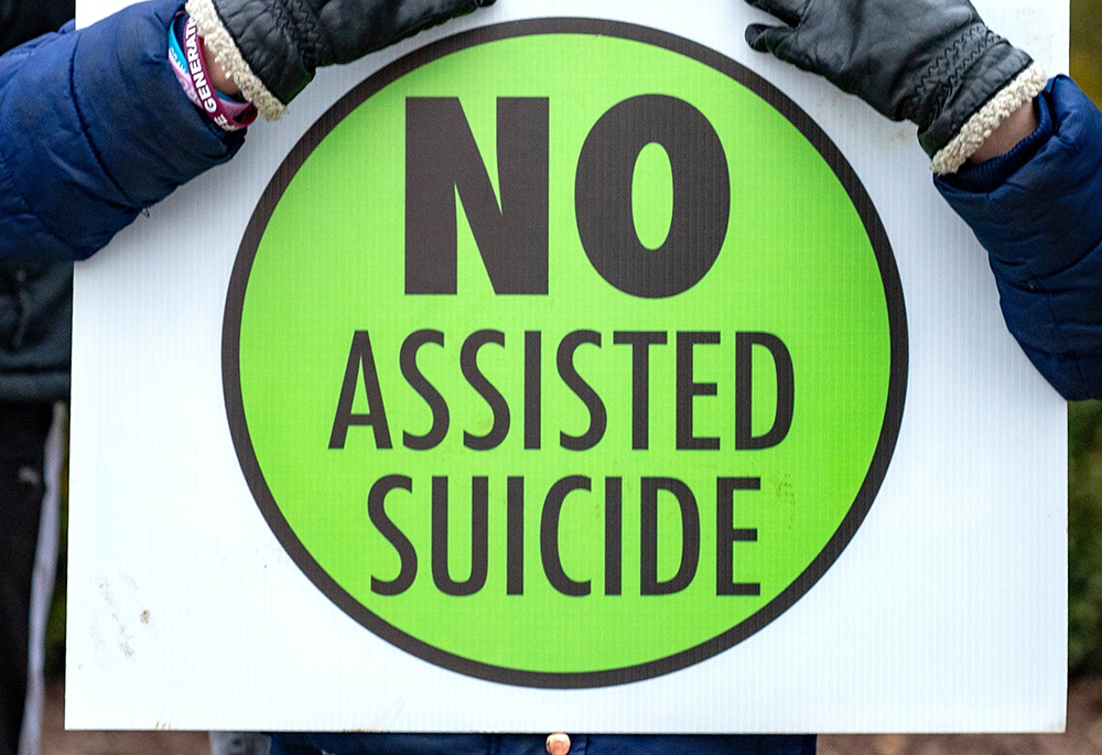 A person is pictured in a file photo holding a sign against physician-assisted suicide. (OSV News/Catholic Review/Kevin J. Parks)