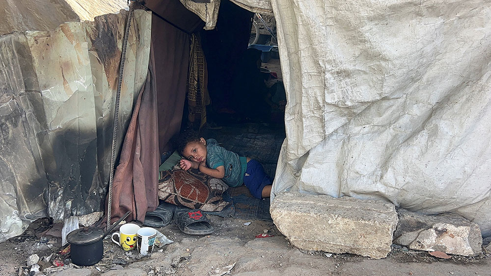 A Palestinian child displaced by the Israeli military offensive lies inside the tent he took shelter in with his family May 25, 2025, in Gaza City, Gaza Strip. (OSV News/Reuters)