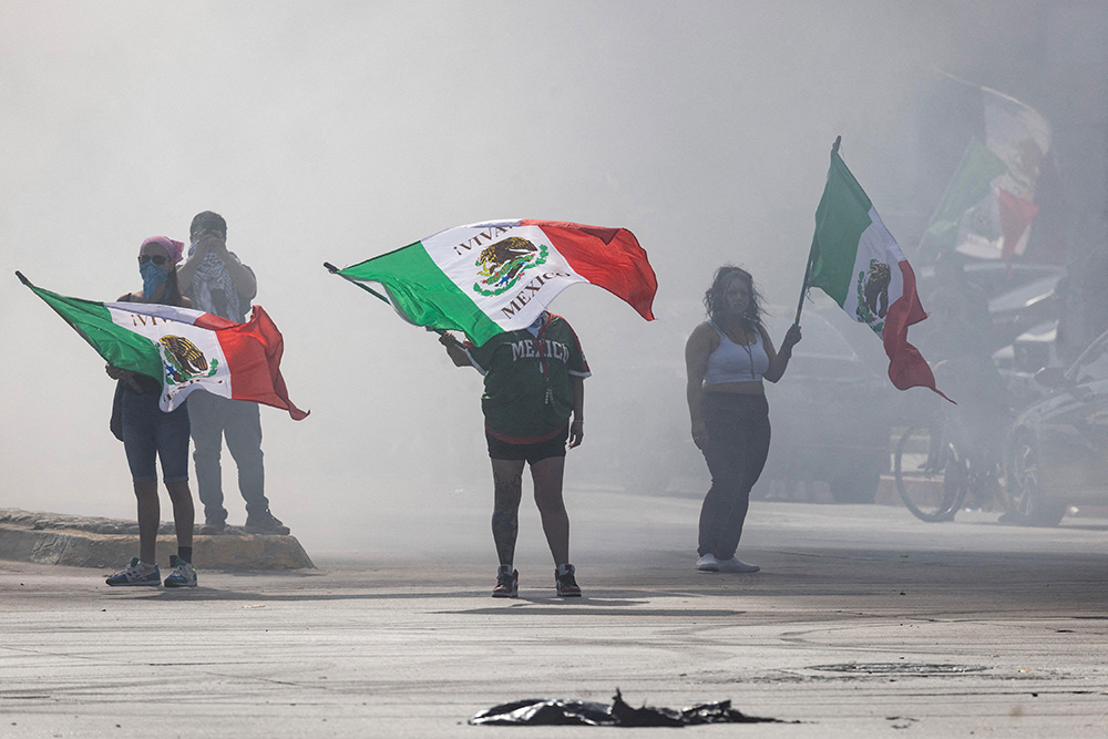 Protesters are blanketed in smoke along Alondra Boulevard during a standoff with law enforcement following multiple detentions by U.S. Immigration and Customs Enforcement in Compton, Calif., June 7, 2025. (OSV News/Reuters/Barbara Davidson)