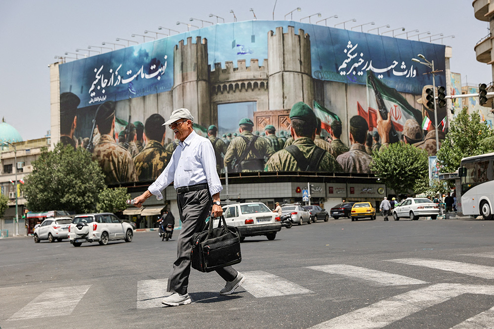 A man walks next to an anti-Israel billboard on a street in Tehran, Iran, June 24, 2025. President Donald Trump announced on social media June 23 that Israel and Iran reached a ceasefire agreement after 12 days of war, however both sides accused the other of violations in the hours afterward. (OSV News/West Asia News Agency via Reuters/Majid Asgaripour)