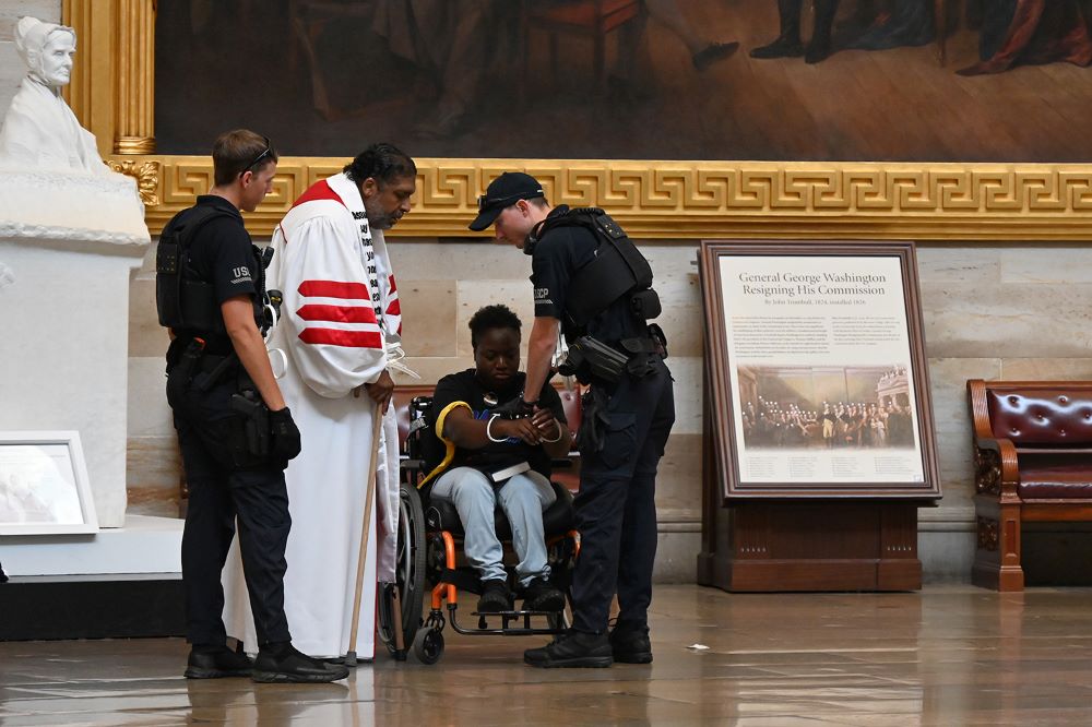 Police arrest the Rev. William Barber II, center left, and Suvya Carroll, center right, in the U.S. Capitol Rotunda June 2 in Washington. Nine people arrested were charged with "crowding, obstructing and incommoding." (RNS photo/Jack Jenkins) Police arrest the Rev. William Barber II, center left, and Suvya Carroll, center right, in the U.S. Capitol Rotunda June 2 in Washington. Nine people arrested were charged with "crowding, obstructing and incommoding." (RNS photo/Jack Jenkins)