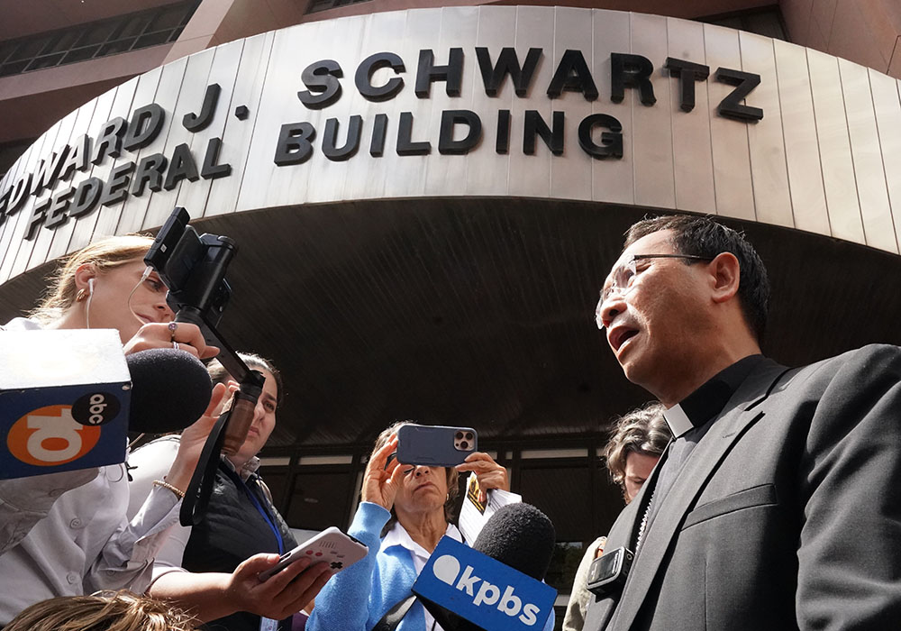 Bishop-designate Michael Pham talks to reporters about his federal court visit to support immigrants at the Edward J. Schwartz Federal Building and U.S. Courthouse on World Refugee Day, June 20 in San Diego. (Chris Stone)
