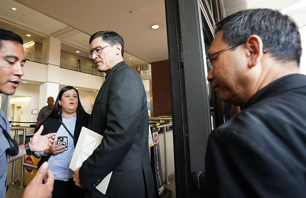San Diego Bishop-designate Michael Pham, right, follows Jesuit Fr. Scott Santarosa into the Edward J. Schwartz Federal Building and U.S. Courthouse on Friday morning, June 20, in downtown San Diego. (Chris Stone)