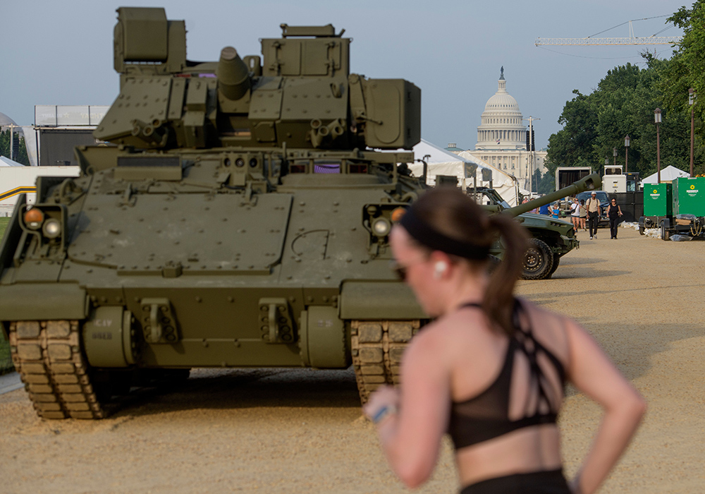 People pass by a tank, parked on the National Mall, during preparations for an upcoming military parade commemorating the Army's 250th anniversary and coinciding with President Donald Trump's 79th birthday, Thursday, June 12, 2025, in Washington. (AP photo/Rod Lamkey, Jr.)