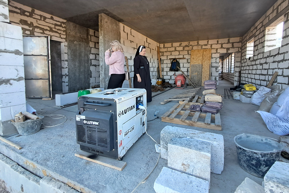 St. Don Bosco School principal Vitalia Vovk takes a call while giving Sr. Lucia Murashko a tour of the new school building in Zaporizhzhia, a city in southern Ukraine. (Marc Roscoe Loustau)
