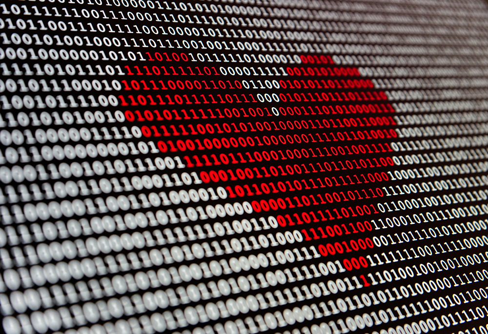 A red heart appears on a black and white computer screen. (Unsplash/Alexander Sinn)
