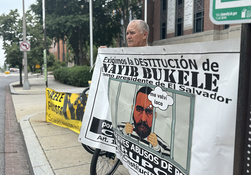 A man holds a poster criticizing Salvadoran President Nayib Bukele outside the Embassy of El Salvador in Washington May 30, 2025. (NCR photo/Rhina Guidos)