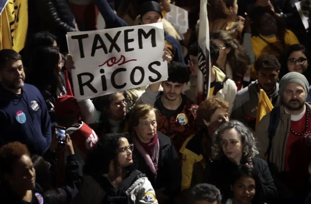 Protesters hold signs that say "tax the rich" during a demonstration in Sao Paulo, Brazil. 