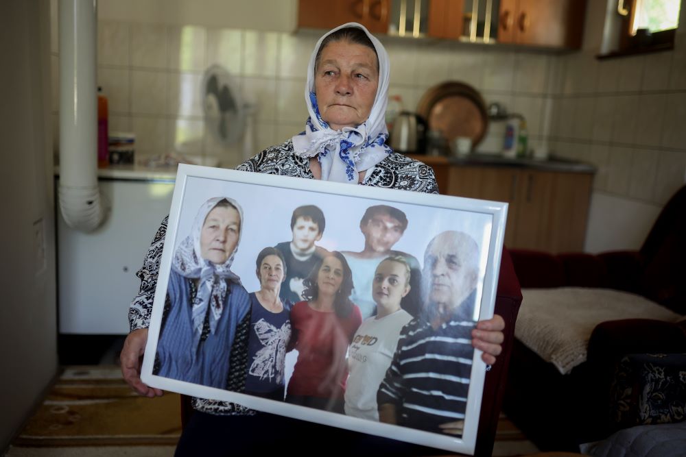 Sefika Mustafic poses for a photo while holding a picture of her family members, victims of the Srebrenica genocide. Sefika Mustafic poses for a photo while holding a picture of her family members, victims of the Srebrenica genocide.