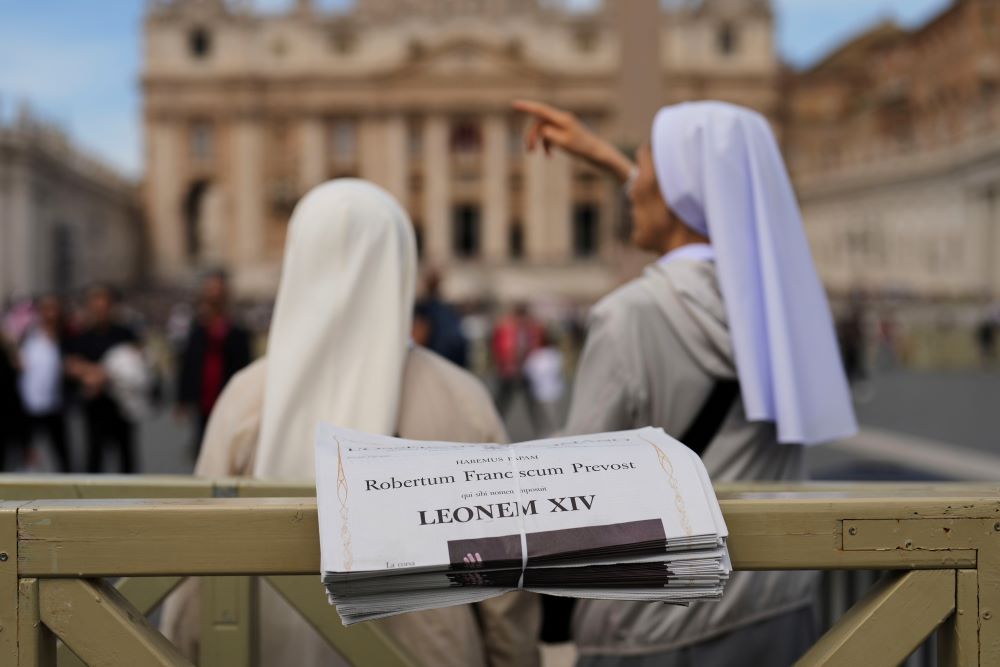 Nuns stand next to copies of L'Osservatore Romano, a Vatican newspaper, with headlines about Pope Leo XIV. Nuns stand next to copies of L'Osservatore Romano, a Vatican newspaper, with headlines about Pope Leo XIV.