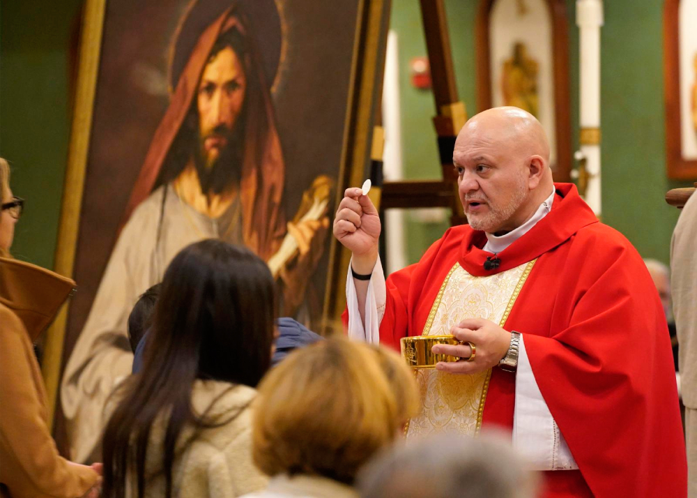 Father Carlos Martins distributes Communion during a special Mass celebrated in honor of St. Jude the Apostle at St. Jude Church in Mastic Beach, N.Y., Nov. 27, 2023. Father Carlos Martins, a member of the Companions of the Cross religious community, distributes Communion during a special Mass celebrated in honor of St. Jude the Apostle at St. Jude Church in Mastic Beach, N.Y., Nov. 27, 2023. Father Martins, a well-known exorcist and co-host of "The Exorcist Files" podcast, has been cleared of charges stemming from a relic exposition held in November 2024 at a parish in Joliet, Ill. (OSV News/Gregory A. Shemitz)