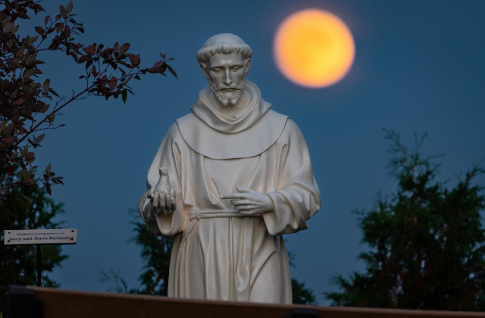 La luna llena de octubre, conocida como Luna del Cazador, se alza detrás de una estatua de san Francisco de Asís en los terrenos del Santuario Nacional de Nuestra Señora de Champion en Champion, Wisconsin, Estados Unidos, el 8 de octubre de 2022. (Foto: OSV News/CNS/Sam Lucero)