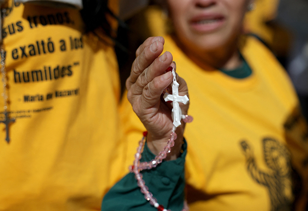 A woman holds a rosary as members of a Catholic group take part in a Eucharistic procession near the U.S. Immigration and Customs Enforcement (ICE) Broadview facility in Chicago Oct. 11, 2025. The group had hoped to share holy Communion with detainees at the facility. (OSV News/Reuters/Jeenah Moon)