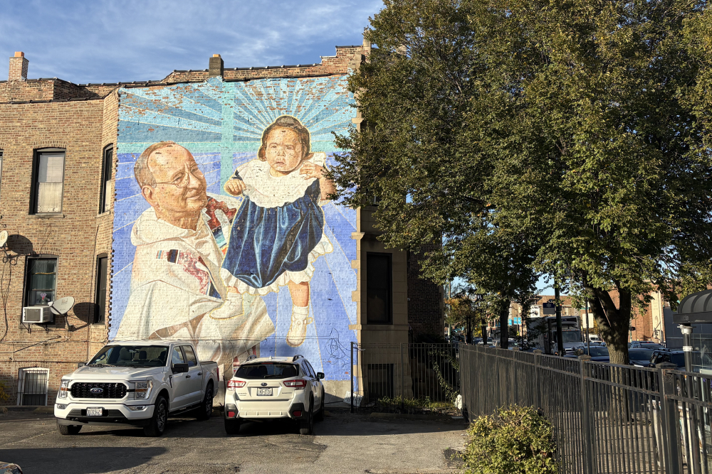 A weathered mural of Dominican Fr. Charles Dahm holding a baby in Chicago’s Pilsen neighborhood.