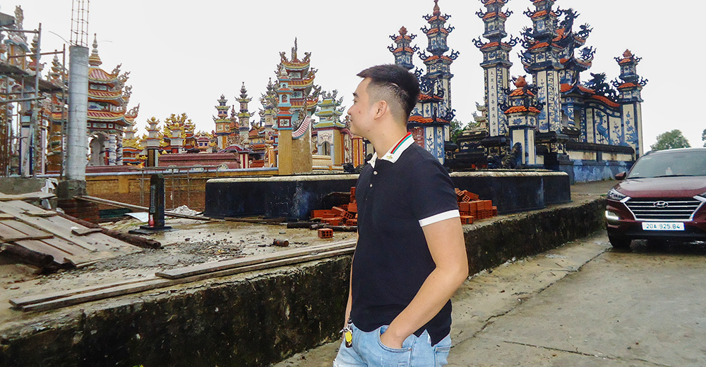 Luke Pham Van Quoc visita la tomba di suo nonno al cimitero il 25 ottobre 2025, fermandosi tra le file di tombe elaborate che si estendono verso il mare. (Joachim Pham)