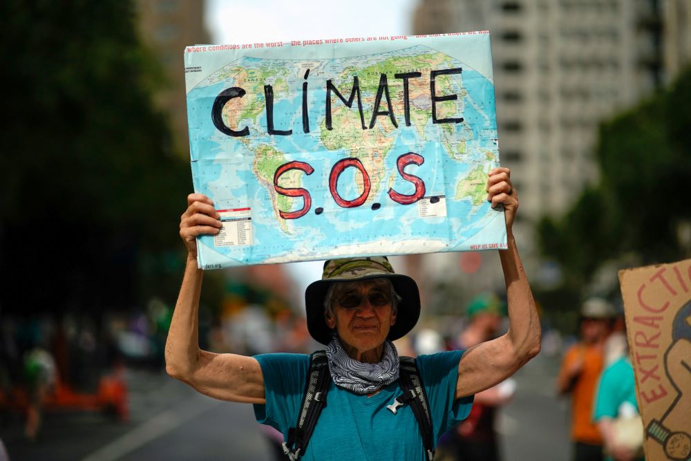 A man holds a sign during a demonstration marking the start of Climate Week in New York City, Sept. 17, 2023. (OSV News/Reuters/Eduardo Munoz)
