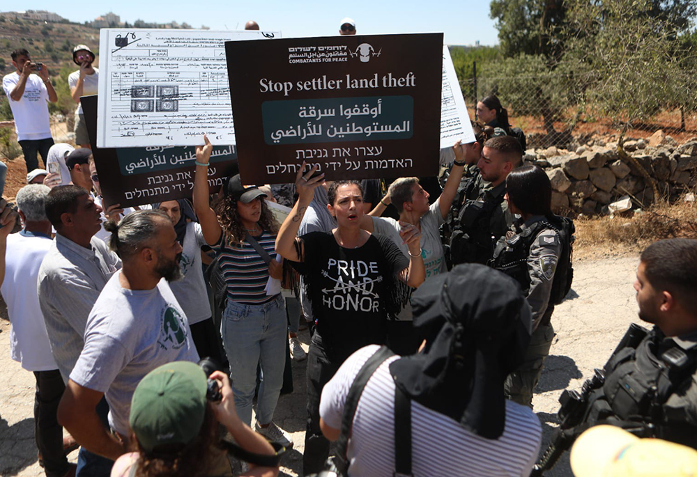 Amira Musallam protests during a nonviolent march against illegal settlers' annexation of Palestinian land in Beit Jala, West Bank, to which Israeli authorities responded with the use of force and stun grenades, in August 2024. (Courtesy of Amira Musallam)