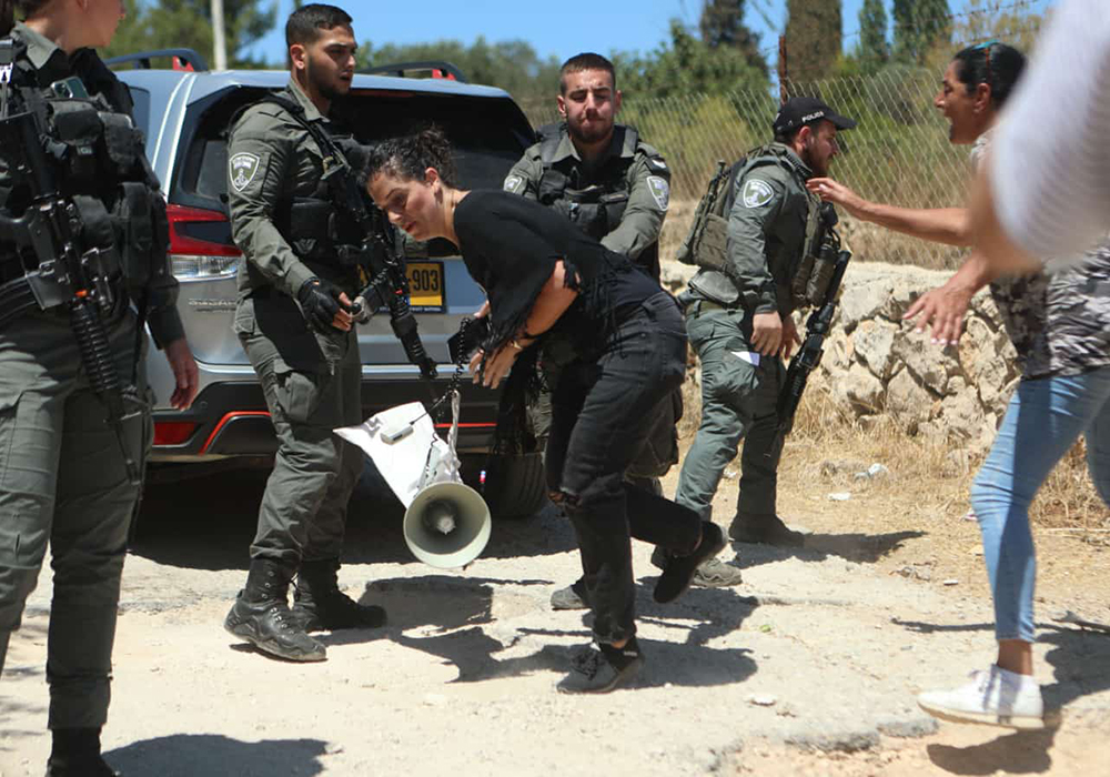 Amira Musallam protests during a nonviolent march against illegal settlers' annexation of Palestinian land in Beit Jala, West Bank, to which Israeli authorities responded with the use of force and stun grenades, in August 2024. (Courtesy of Amira Musallam)