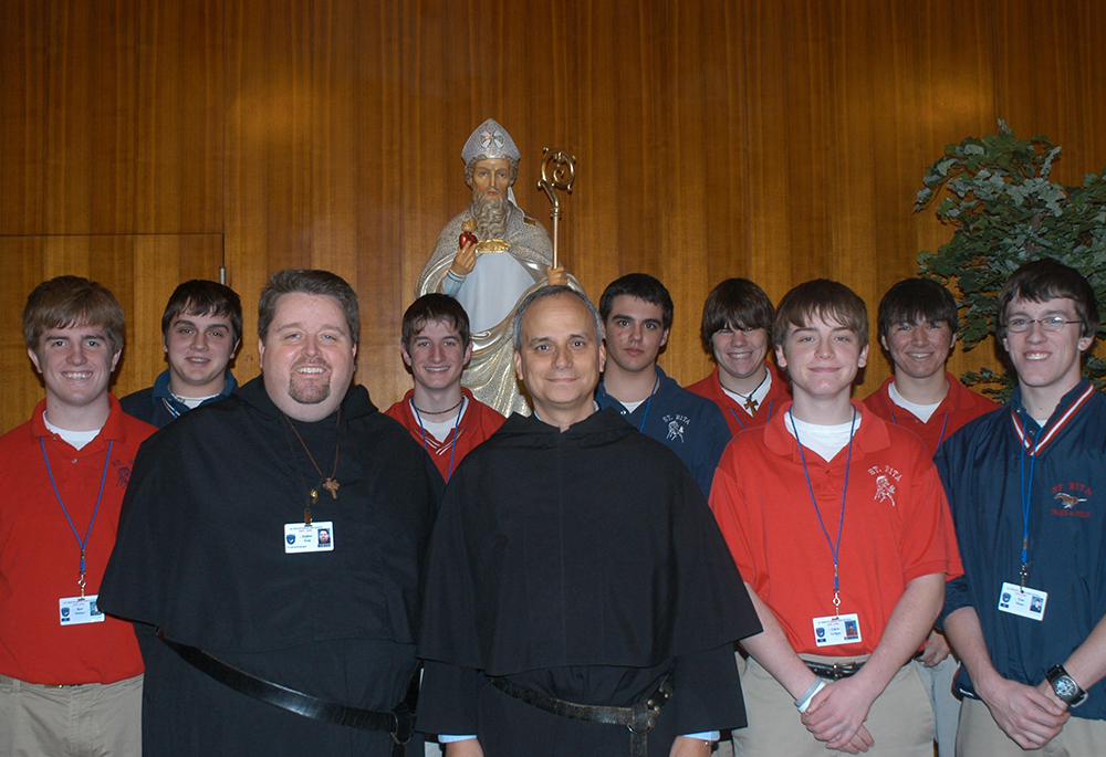Allora-Fr. Robert F. Prevost, ora Papa Leone XIV, centro anteriore, priore generale dell'ordine agostiniano, posa con l'agostiniano Fr. Tom McCarty, presidente di St. Rita High School di Chicago, e upperclassmen nel gennaio 2006. (OSV News/Per gentile concessione di The Beverly Review)
