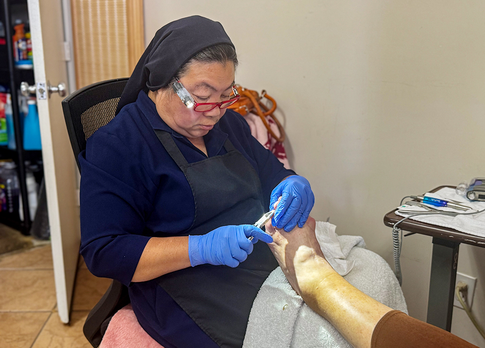 Daughter of Charity Sr. Oanh Tran clips the nails of a diabetic woman June 10, 2026, at the Fr. Virgil Cordano Center in Santa Barbara, California. (GSR photo/Rhina Guidos)