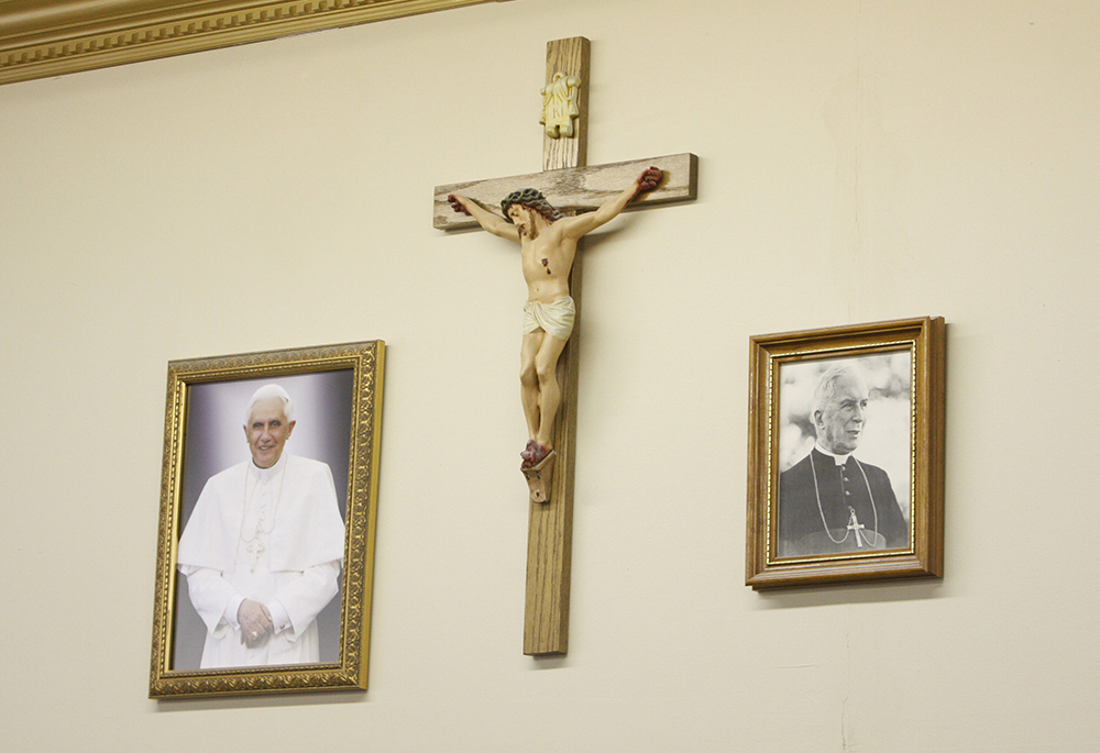 Portraits of Pope Benedict XVI and Archbishop Marcel Lefebvre, founder of the Society of St. Pius X, flank a crucifix in the community room at St. Michael the Archangel Chapel in Farmingville, New York, Feb. 1, 2009. (CNS/Gregory A. Shemitz)