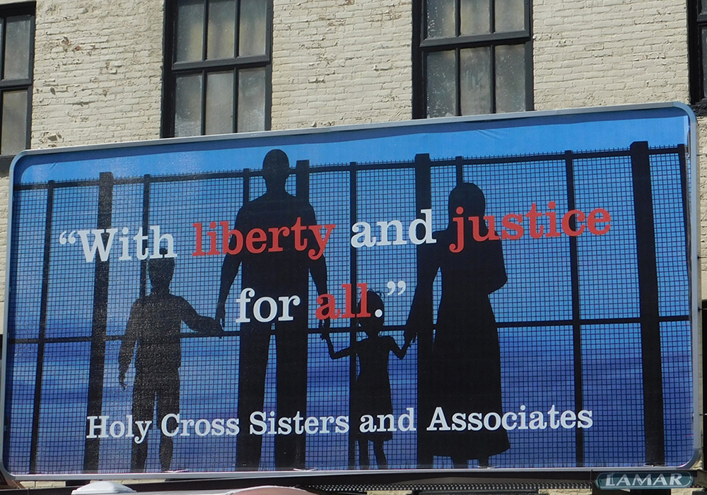 In this 2019 photo, a billboard sponsored by the Holy Cross Sisters and Associates is seen in Merrill, Wisconsin, to draw attention to the plight of immigrant families in the United States. (CNS photo/courtesy Holy Cross Sisters USA Province)