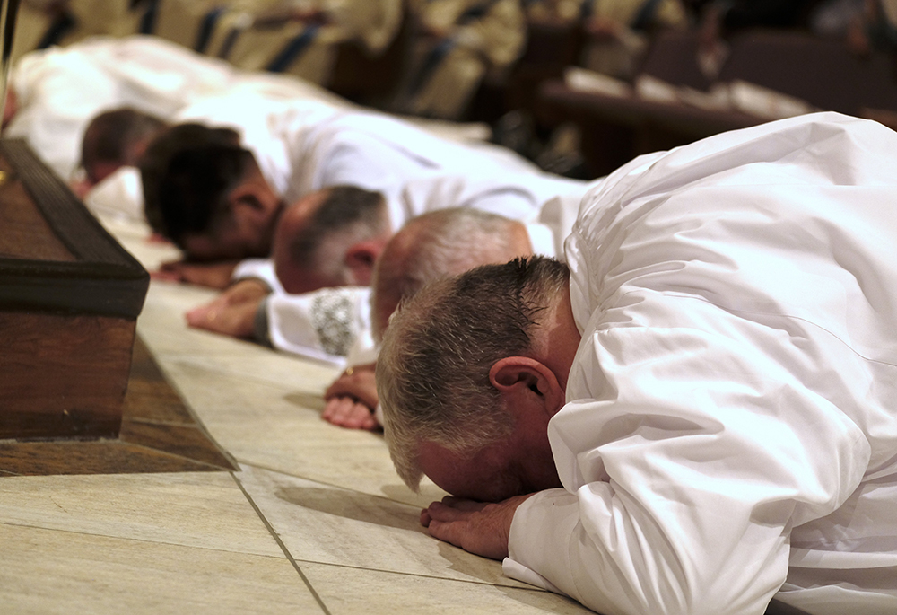 Men lie prostrate during their ordination to the diaconate at the Catholic Pastoral Center in Nashville, Tennessee, April 1, 2023. (OSV News/Tennessee Register/Katie Peterson)