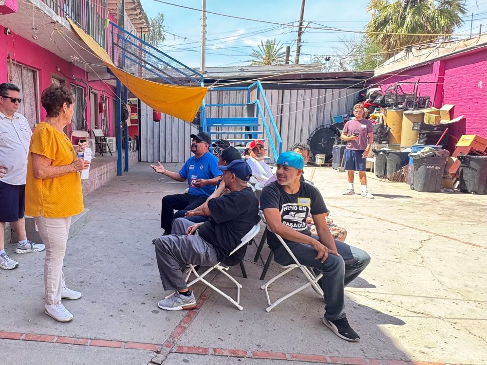 St. Joseph of Carondelet Sr. Suzanne Jabro, in yellow, talks to a group of men at the Cobina Posada del Migrante shelter June 6, 2026. Jabro is the founder of Border Compassion, which facilitates encounters between migrants, sisters, ecumenical groups and others. (GSR photo/Rhina Guidos)
