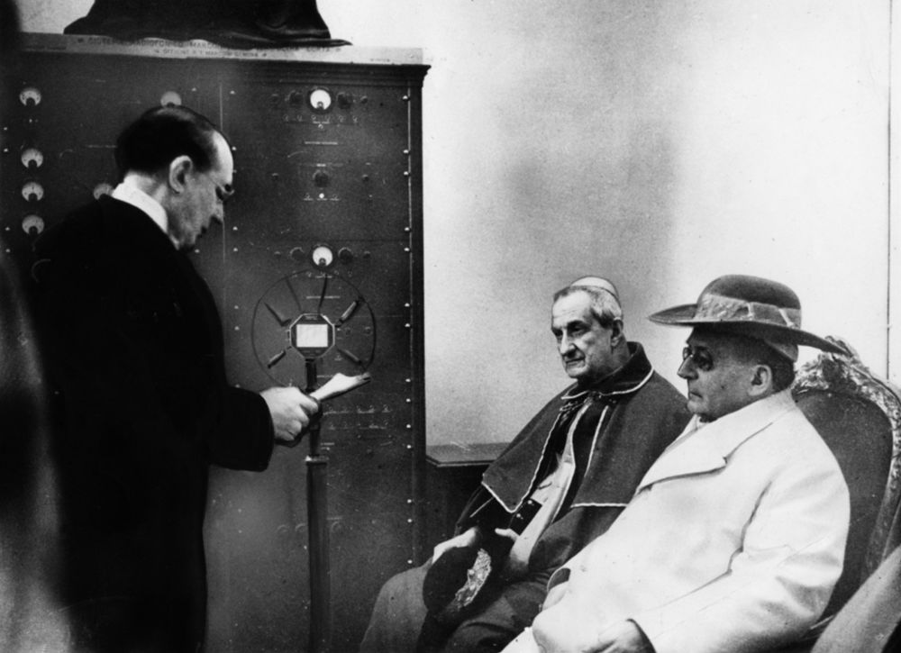 Pope Pius XI, founder of Vatican Radio, right, listens to the address of Guglielmo Marconi, the inventor of radio, during a 1933 ceremony inaugurating the world's first station for radio communication by ultrashort wave. In "Quadragesimo Anno," Pius lamented the "economic dictatorship" the Industrial Revolution created. (CNS) 