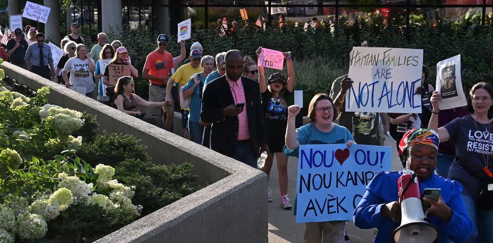 Mia Perez, right, with Voices of Immigrants organization, leads a march as community leaders and residents gather for a rally at City Hall in support of Haitians Aug. 16, 2026, in Springfield, Ohio. (RNS/Carol Guzy)