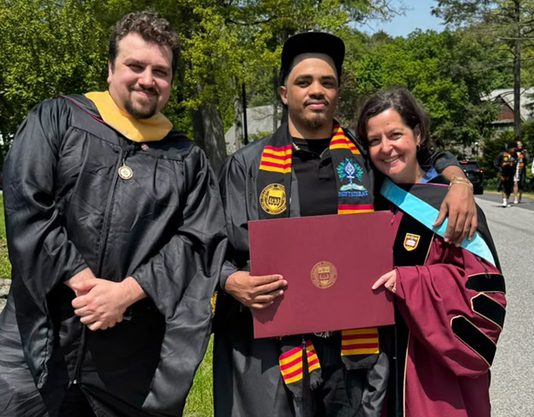 Jesuit in formation Mario Verde, left, student Pablo Abreu and student success director Genevieve Green pose at graduation at Boston College, May 2026. (Courtesy of Genevieve Green)