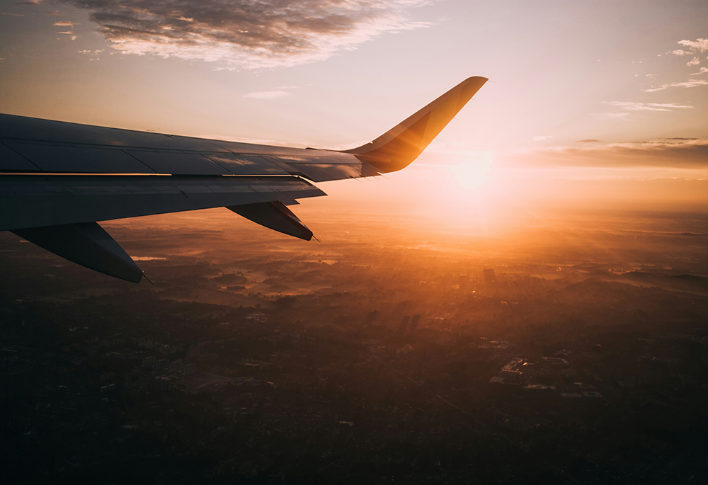 The sun is seen in a shot of a town's horizon, which looks to taken from an airplane (Unsplash/Nils Nedel)
