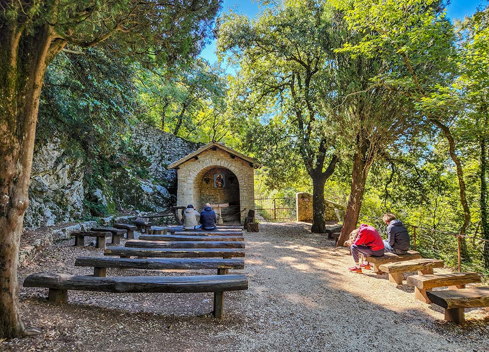People pray at an outdoor altar at Eremo delle Carceri on Monte Subasio in Italy. (NCR photo/Brian Roewe)