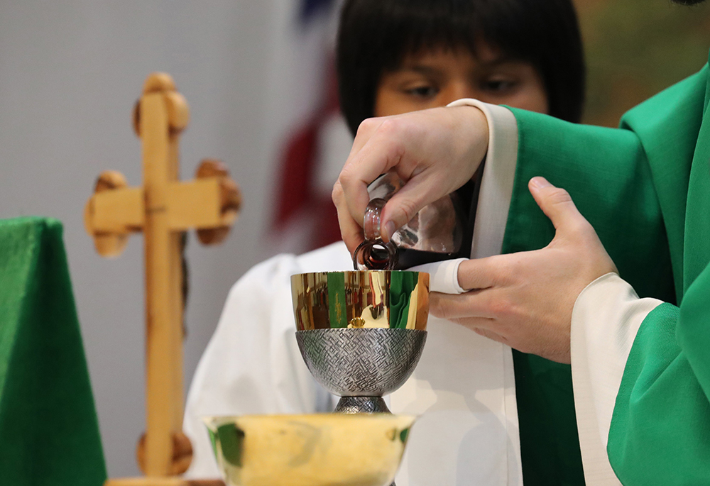 A priest is seen in a file photo pouring wine into the chalice during the offertory of the liturgy of the Eucharist as he celebrates morning Mass. (OSV News/Bob Roller)
