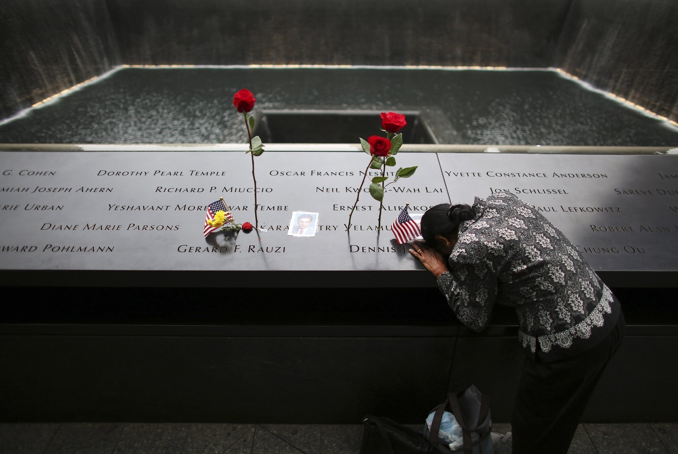 A woman grieves at the inscription of her late husband's name at the national 9/11 Memorial and Museum in New York City Sept. 11, 2014. (OSV News/Reuters/Chang Lee)
