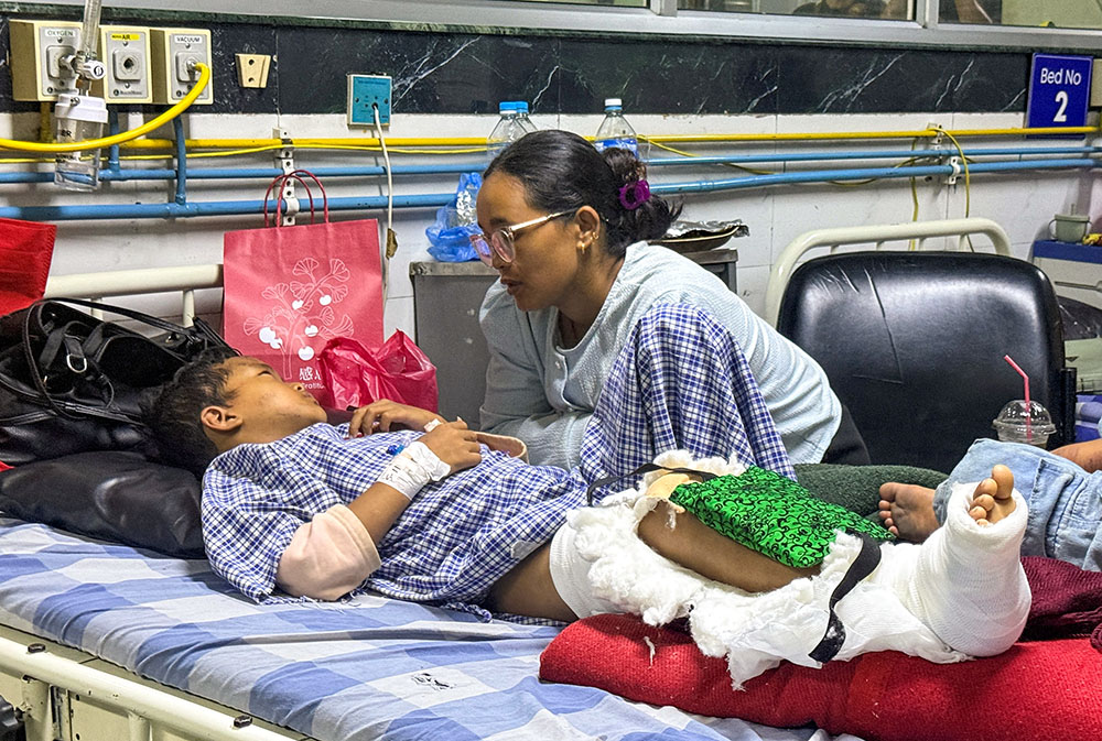 At a hospital in Kathmandu, Nepal, Aug. 28, 2026, Matti Maya Tamang speaks with her son Zoyal Ghale, 8, who was injured in the Aug. 26 deadly flash floods and mudslide. (OSV News/Reuters/Ranup Shrestha)