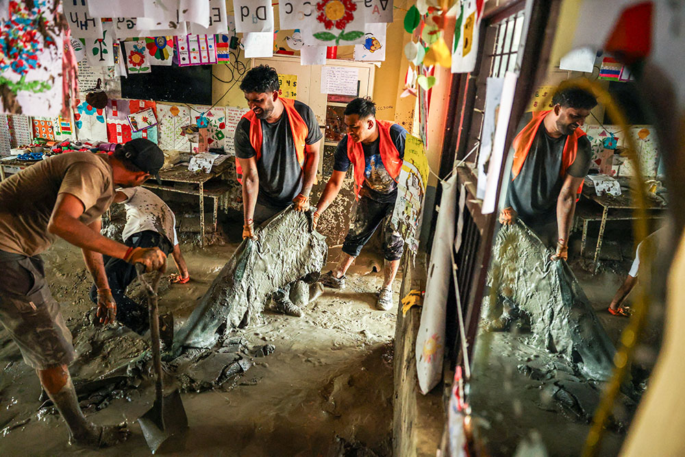 Volunteers remove sludge inside a classroom at Shree Bagheswori Madhyamik School at Galchhi in Nepal's Dhading district following deadly flash floods and mudslides. (OSV News/Reuters/Athit Perawongmetha)
