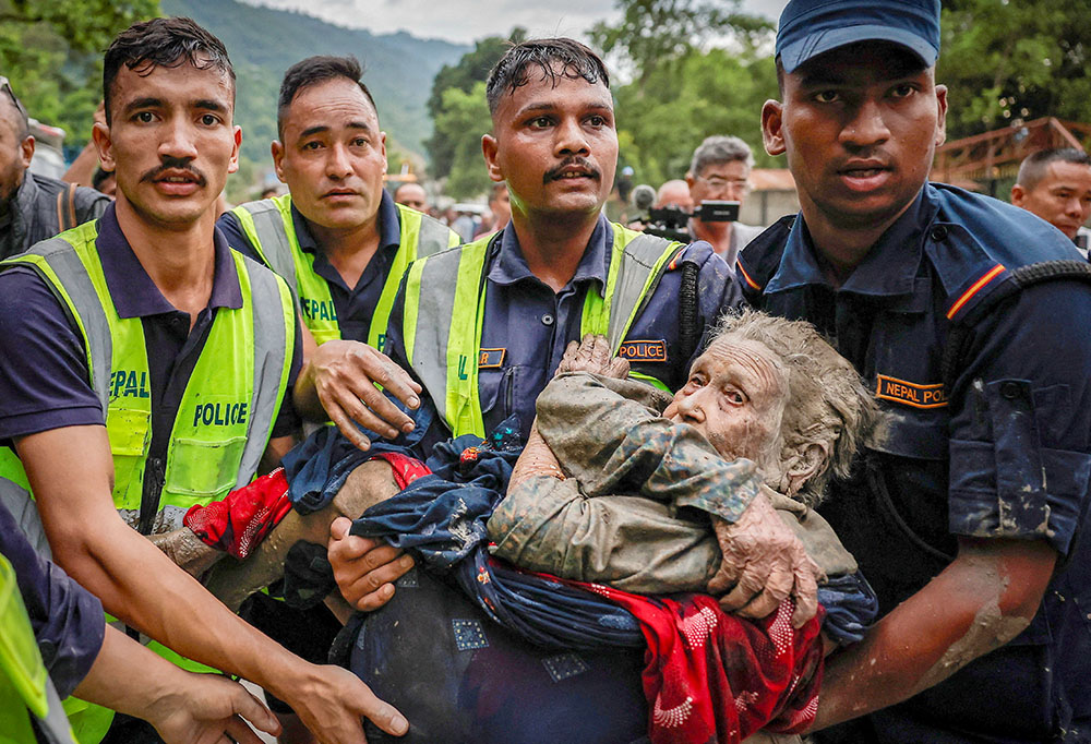 Police officers carry an elderly survivor to a safer place at Devighat in Nepal's Nuwakot district, Aug. 30, 2026, following deadly flash floods and mudslides. (OSV News/Reuters/Navesh Chitrakar)